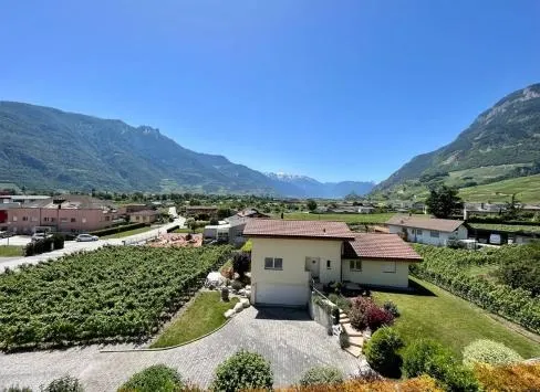 Une maison valaisanne et son terrain, vus du ciel, la vallée du Rhône derrière