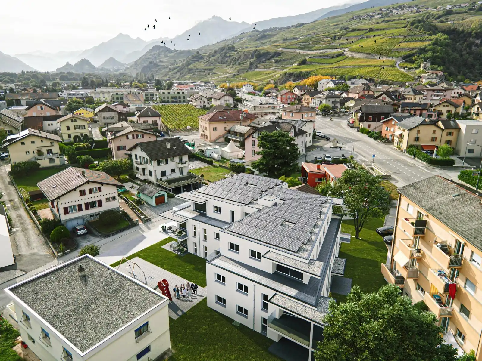Un immeuble neuf vu du ciel, au pied des vignes en terrasses