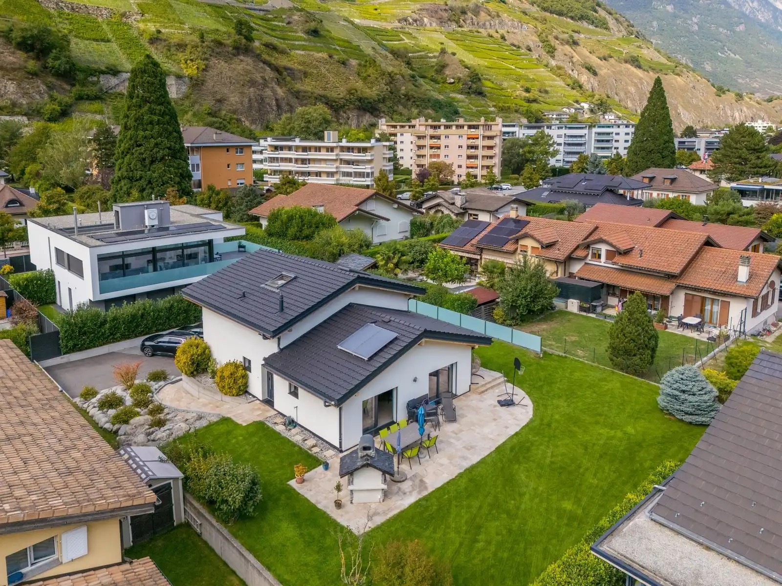 Une villa contemporaine vue du ciel, son jardin et le coteau derrière